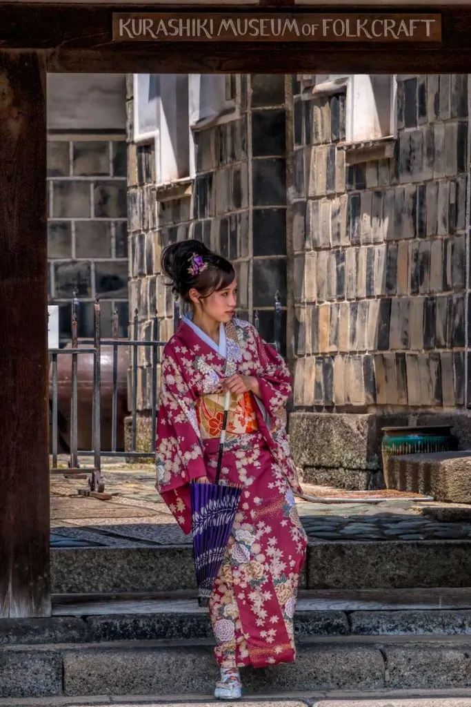 Girl in kimono exits the Kurashiki  museum of folkcraft