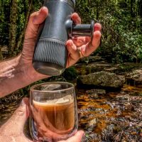Using the Wacaco Nanopresso coffee press beside a creek in the rainforest