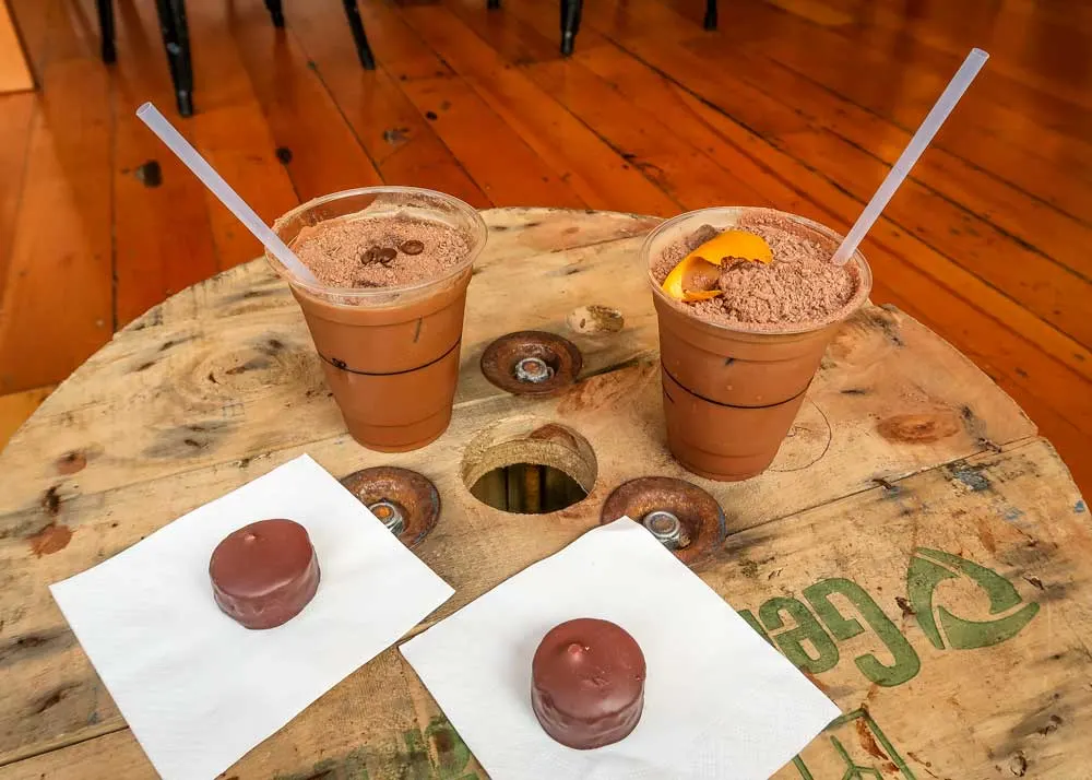 Iced chocolate and handmade chocolate on wooden cable roll cafe table