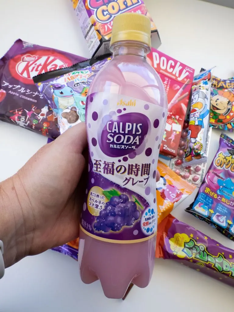 Calpis grape soda flavour with snacks in the background