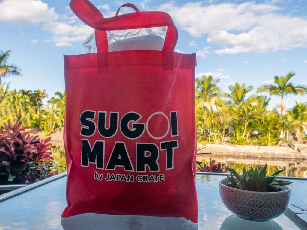 Sugoi Mart review - lucky bag in front of lagoon and palm trees